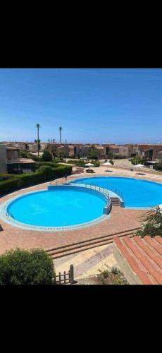 a large blue swimming pool in a park at Luxury Duplex Villa for Rent in Dawwār Muḩammad Abū Shanab