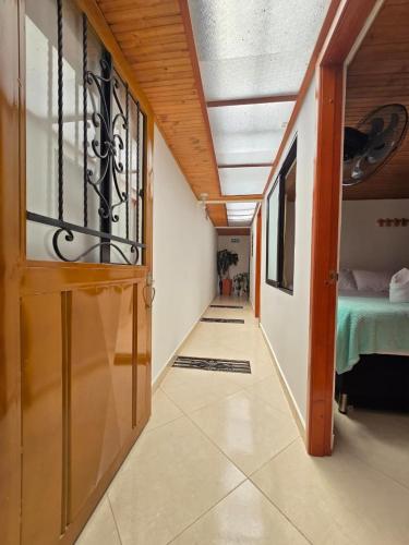a hallway with a room with a bed and a door at Hotel El Balcon de madera in Norcasia