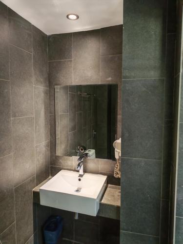 a bathroom with a sink and a mirror at Hotel 99 Kota Kemuning in Shah Alam