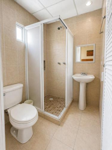 a bathroom with a shower and a toilet and a sink at Hotel Tulipanes in Villahermosa