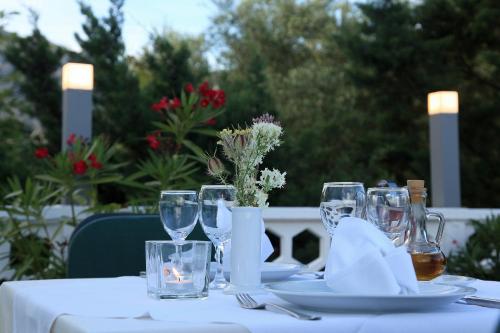 a table with a white table cloth and wine glasses at Hotel Rajna in Starigrad