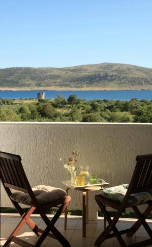 a pair of chairs and a table on a balcony at Hotel Rajna in Starigrad-Paklenica