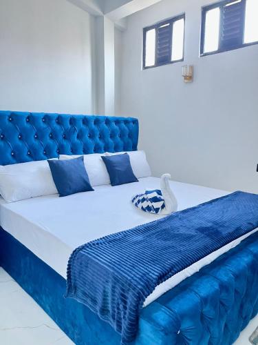 a blue bed with a blue tufted head board at Lavenia Mountain Holiday home in Bandarawela
