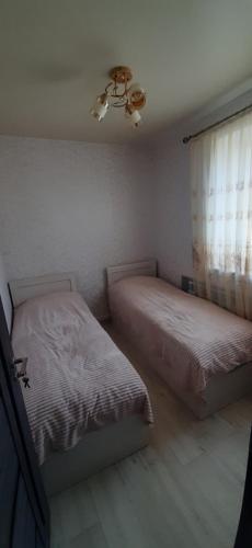 a bedroom with two beds and a ceiling fan at Гостевой дом in Sevan
