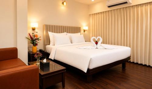 a hotel room with a bed with two swans on it at Ello Hotels in Bangalore