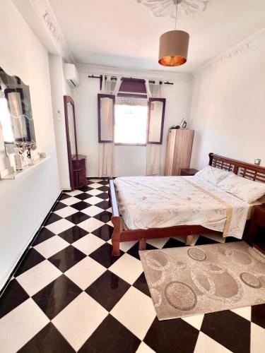 a bedroom with a bed and a checkered floor at Blue Pearl city in Chefchaouen