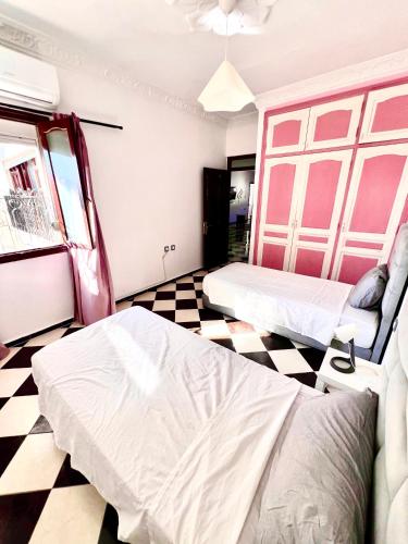 a room with two beds and a checkered floor at Blue Pearl city in Chefchaouen