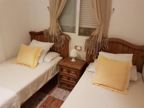 Un dormitorio con dos camas y una ventana con cortinas. en Aalia villa, en Villacosta