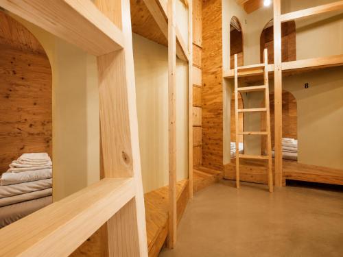 a room with wooden walls and bunk beds at Ishigaki Guesthouse HIVE in Ishigaki Island