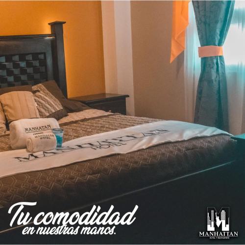 a bed with a sign on top of it at Hotel y Restaurante Manhattan in La Tenería
