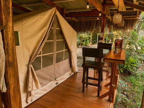 a tent on a porch with a table and chairs at Soffta Surf Ranch in General Luna