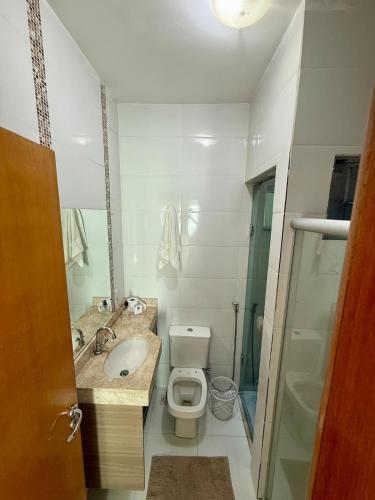 a bathroom with a toilet and a sink and a mirror at Sobrado Flamboyant in Goiânia
