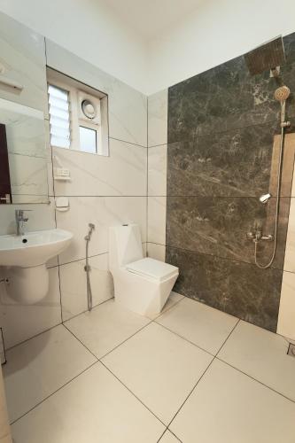 a bathroom with a toilet and a sink at Rivera Residency , Kazhakuttom in Murukkumpuzha