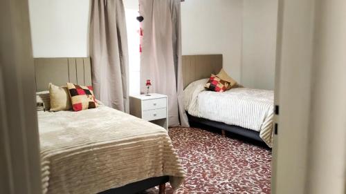 a small bedroom with two beds and a window at "Alojamiento en Uspallata" para hasta 6 personas in Uspallata