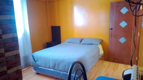 a bedroom with a bed in a yellow room at Hostal Sin fronteras in Uyuni