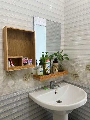 a bathroom with a sink and a mirror at Nhà của Buôn in Buon Ma Thuot