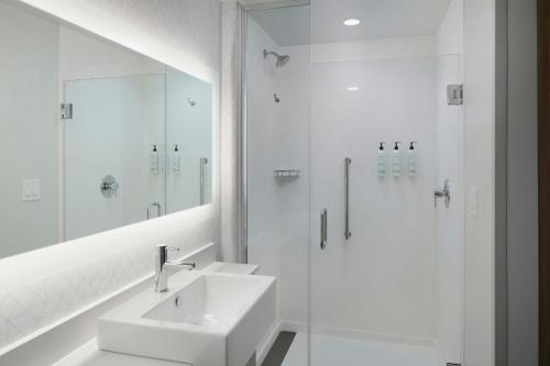 a white bathroom with a sink and a shower at SpringHill Suites by Marriott High Point Downtown in High Point
