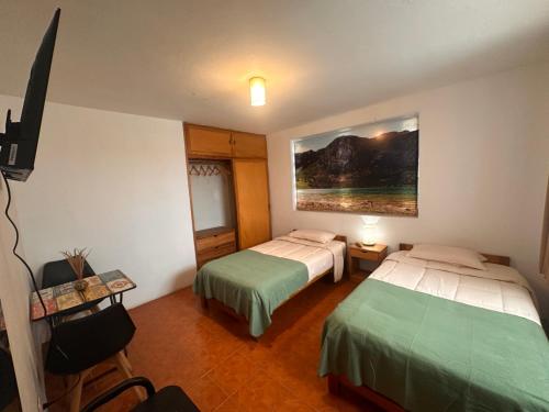a hotel room with two beds and a painting on the wall at Amelita Hotel Boutique in Huaraz