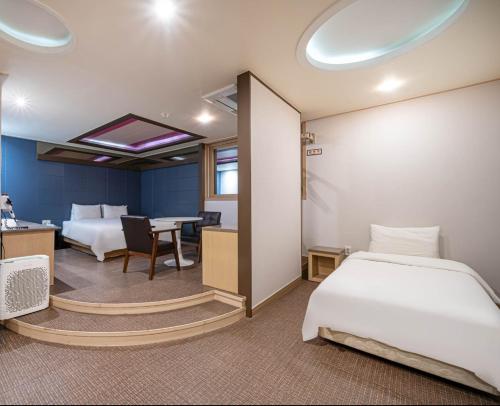 a bedroom with two beds and a desk and a table at W Hotel in Yangsan