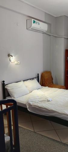 a bed in a room with a white bed sidx sidx sidx at ΚΑΡΔΙΤΣΑ οικογενειακο in Karditsa