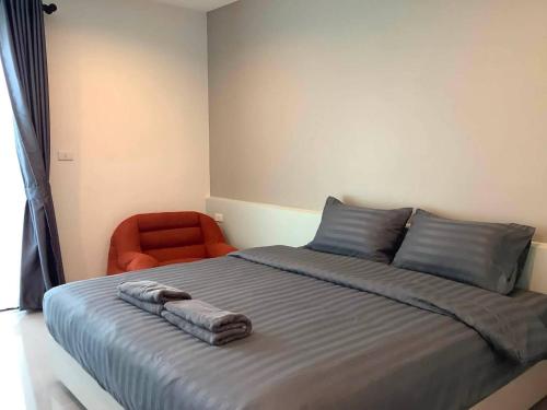 a bedroom with a bed and an orange chair at The Camp in Kanchanaburi City