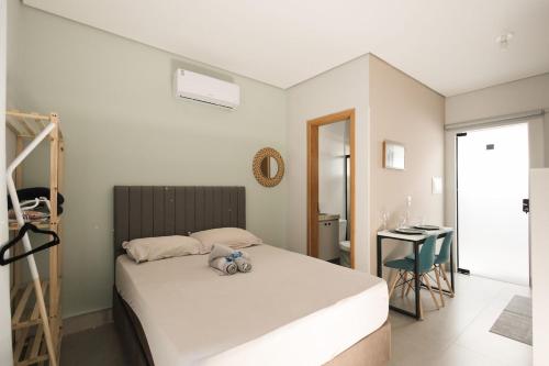 a bedroom with a bed with a teddy bear on it at 4-Studio Completo com Ar-Condicionado, TV e Lavanderia in Londrina