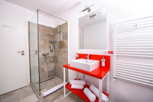 パルティニシュにあるPensiune Rara Paltinisのバスルーム(赤いシンク、シャワー付)