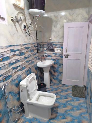 a bathroom with a toilet and a sink at Cedar Crest Homestay in Kulu