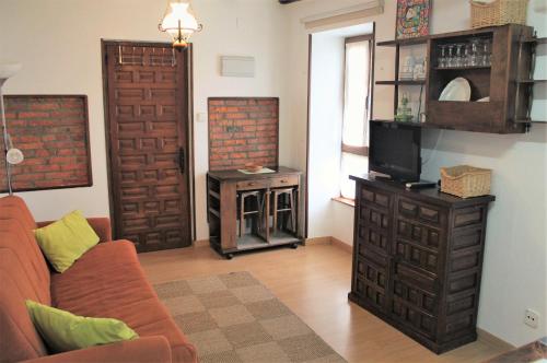 a living room with a couch and a tv and a fireplace at Apartamentos Maite in Oreña