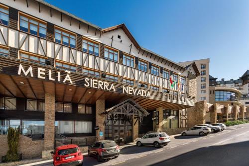 a hotel with cars parked in front of it at Meliá Sierra Nevada in Sierra Nevada