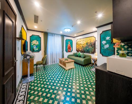 a living room with a green couch and a table at Nature Hotel and Spa Ha Noi in Hanoi