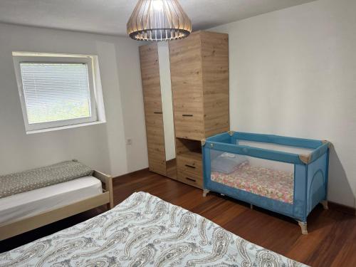 a bedroom with a bed and a dresser and a crib at Casa Illyria in Gusinje