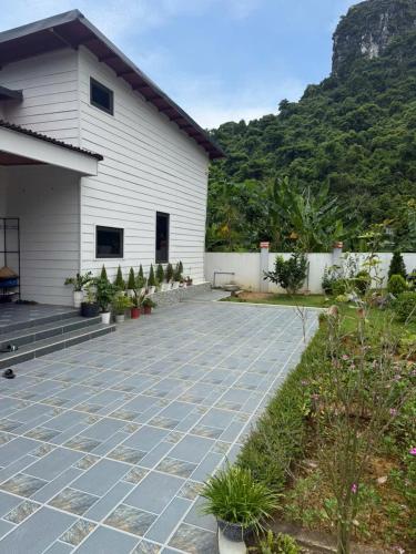 a house with a stone patio next to a building at CoNa Homestay in Ðồng Khê Sâu