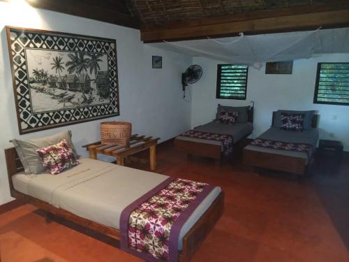 a bedroom with a bed and a couch in a room at Boraha Village Ecolodge in Ambodifototra