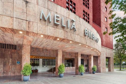 ein Nachrichtengebäude mit Topfpflanzen davor in der Unterkunft Meliá Bilbao in Bilbao
