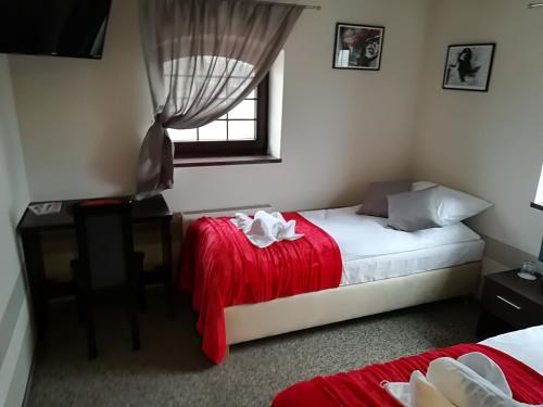 a bedroom with a bed and a desk and a window at Młyn in Chodecz