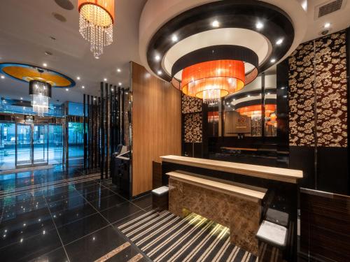 a lobby of a store with a bench and chandeliers at APA Hotel Ueno Ekikita in Tokyo