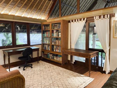 a home office with a desk and a book shelf at Villa Layangan - Two Bedrooms with Pool Access in Sanur
