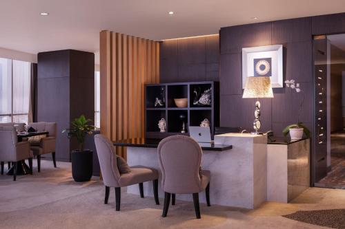 a dining room with a table with chairs and a laptop at Meliá Makassar in Makassar