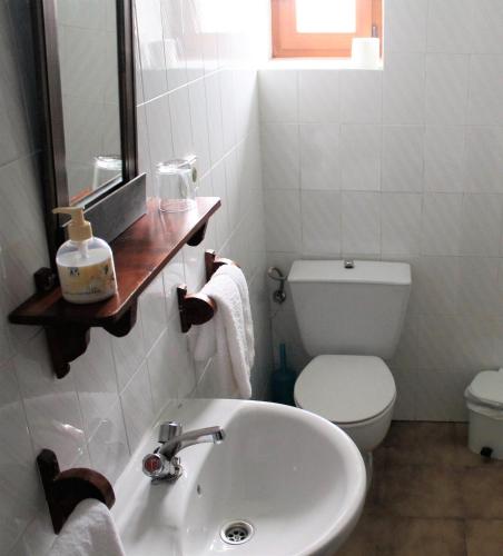 a white bathroom with a sink and a toilet at Apartamentos Maite in Oreña
