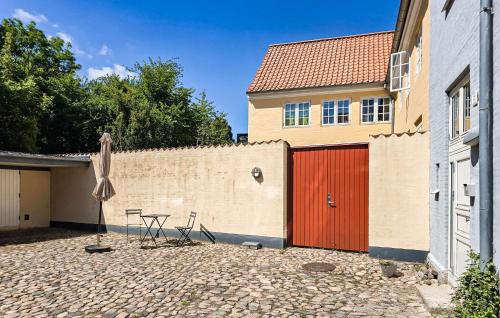 a patio with a table and an umbrella and a building at 2 Bedroom Nice Apartment In Faaborg in Faaborg