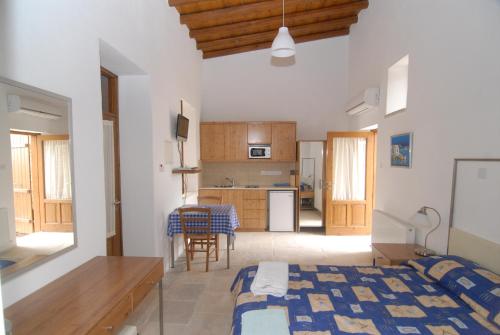 a bedroom with a bed and a kitchen with a table at Anesi House in Skarinou