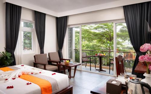 a hotel room with a bed and a balcony at Indra Angkor Hotel in Siem Reap