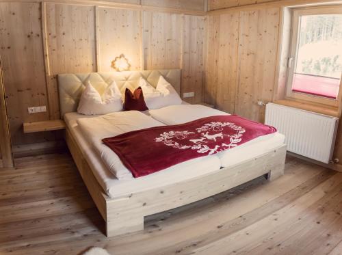 a bedroom with a large bed in a room with wooden walls at Joggelerhof in Finkenberg