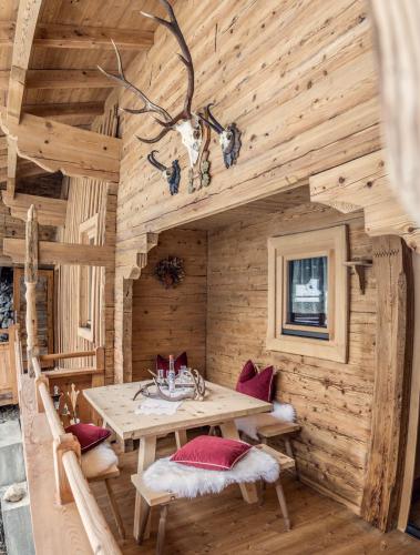 a dining room in a log cabin with a table and chairs at Joggelerhof in Finkenberg