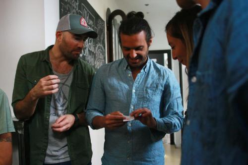 a group of three men looking at a cell phone at The Lights Hostel in Málaga