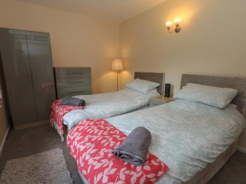 a bedroom with two beds with towels on them at West End House in Bradford
