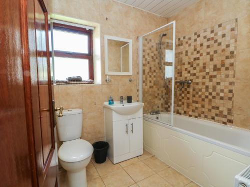 a bathroom with a toilet and a sink and a tub at West End House in Bradford