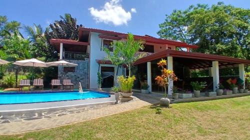 a house with a swimming pool in front of it at Machan Villa in Tangalle