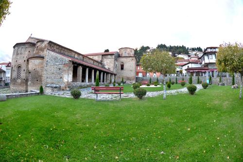 a park with a bench in front of an old building at Jovanovic Guest House in Ohrid